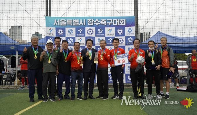 지난 10월 11일과 12일, 성동구 살곶이체육공원 축구장에서 열린 ‘서울시 7080 장수축구대회’에 참석한 김용호 서울시의원(왼쪽 여섯 번째)이 70대B조에서 우승한 용산구 70대 장수축구단에게 우승컵과 트로피를 시상한 후 기념촬영을 하고 있다.