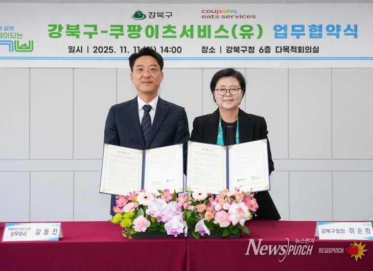 이순희 강북구청장(오른쪽)과 강동진 쿠팡이츠서비스 상무이사가 11일 강북구청 다목적회의실에서 업무협약을 체결한 뒤 협약서를 들어 보이고 있다.