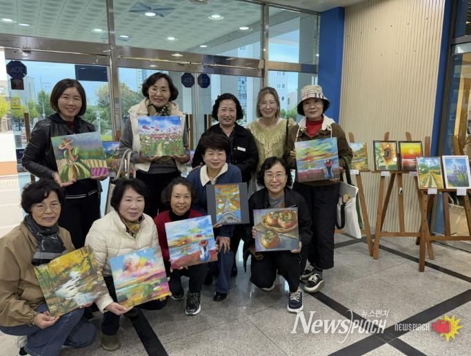 힐링아트(오일파스텔) 전시회’ 현장에서 사천시복지청소년재단 경영본부장(변은진), 강사(박홍은), 회원들이 전시 성료를 기념하며 단체사진을 촬영하고 있다.