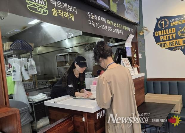 성남시 어린이 기호식품 전담관리원이 지난 9월 학교 주변 햄버거 판매점에서 영업자와 종업원의 건강진단 실시 여부를 점검하고 있다