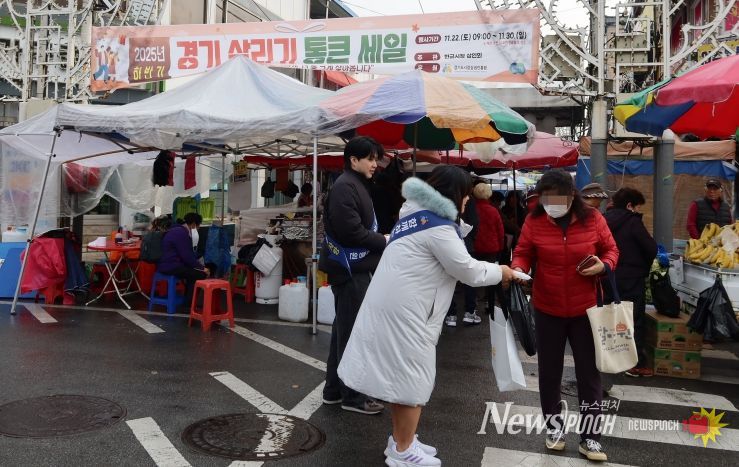 경상원이 여주한글시장을 방문한 도민들에게 '통큰 세일' 홍보물을 나눠주고 있다.