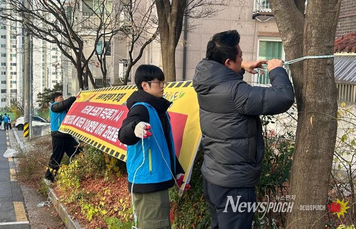 서경대학교 학생들이 무단투기 금지 현수막을 달고 있다.