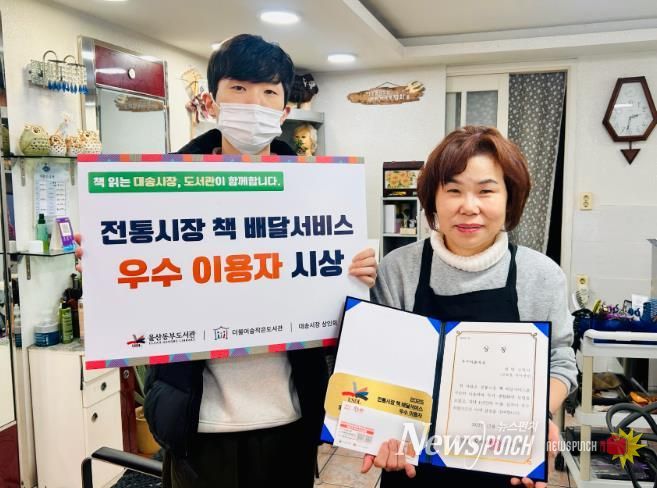 대송시장 헤어세상 심영미 사장이 동부도서관이 주관한 '전통시장 책 배달 프로그램' 우수이용자상을 받고 기념사진을 찍고있다