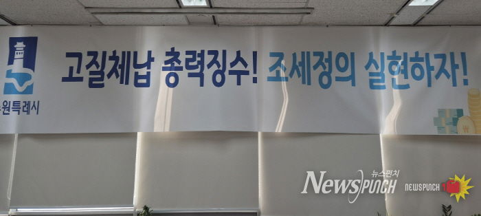 ‘고질체납 총력 징수! 조세정의 실현하자!’ 수원시 징수과 사무실에 걸려 있는 현수막.