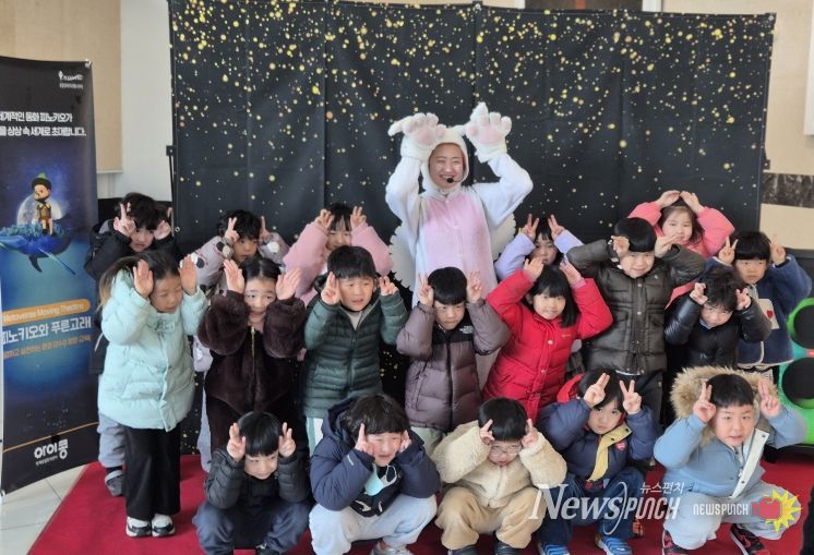 아이들이 공연 출연자와 함께 기념촬영을 하고 있다.