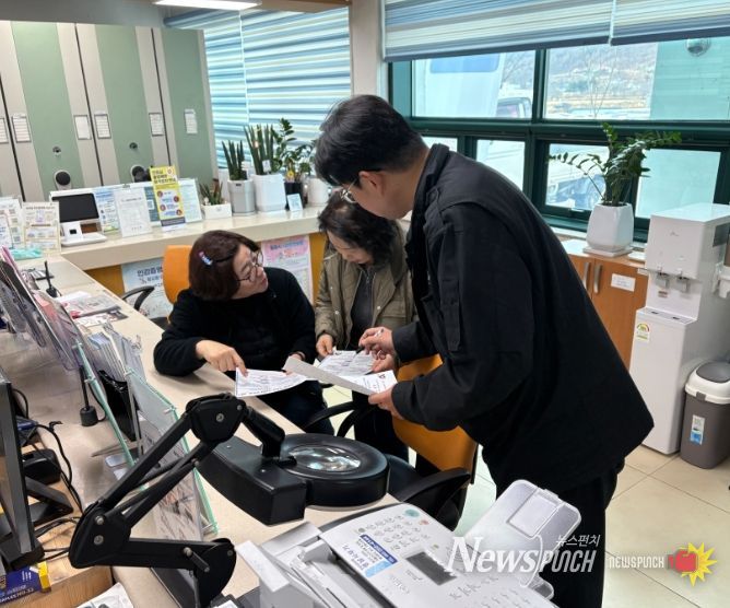 25일 밀양시 상동면행정복지센터 직원이 방문 민원인에게 저소득층 치과 진료비 지원사업을 안내하고 있다.