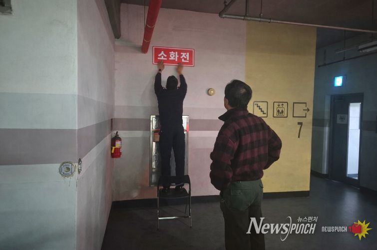 영동소방서 관계자가 아파트 지하주차장에 '보이는 소화전' 표지를 부착하고 있는 모습