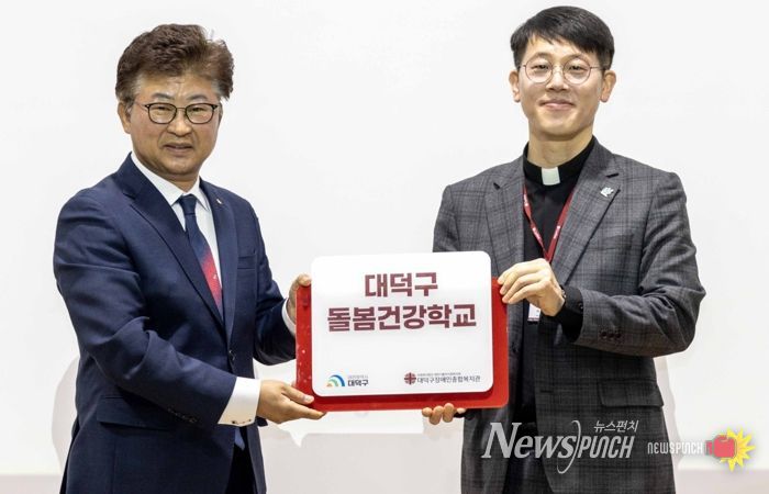 최충규 대덕구청장과 서용원 대덕구장애인종합복지관 관장이 12일 대덕구장애인종합복지관에서 열린 ‘돌봄건강학교 입학식’에서 현판을 들고 기념촬영을 하고 있다.