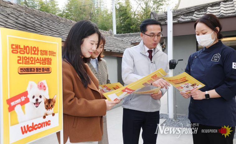 박희조 동구청장과 직원들이 반려견 동반음식점에서 설명을 듣고 있다