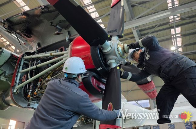 고정익 항공기 프로펠러를 교체중인 해양경찰관