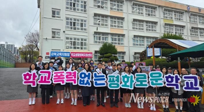 강북교육지원청 한성기 교육장과 학생들이 31일 무룡중학교에서 등굣길 학교폭력 예방 홍보활동을 하고 기념사진을 찍고있다