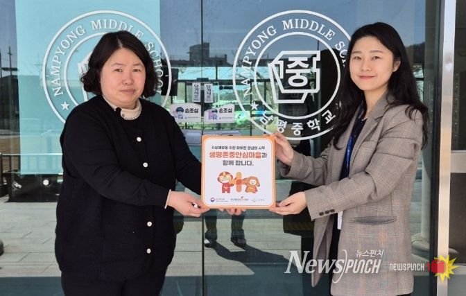 나주시보건소가 남평중학교에 생명 존중 안심마을 현판을 전달하고 있다.
