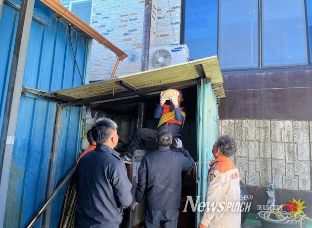 장흥소방서가 화목보일러실 천장에 자동확산소화기를 설치하고 있다.