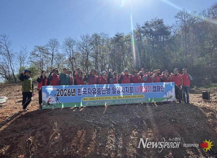 한국자유총연맹 밀양시지회 회원들이 나무심기 행사를 개최하고 기념 촬영을 하고 있다.